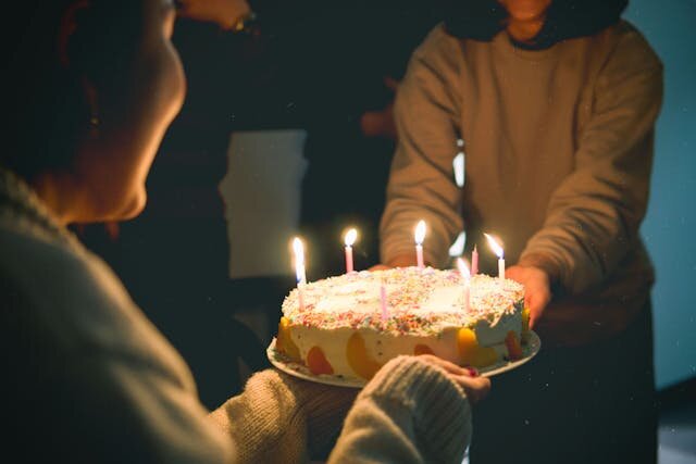 誕生日ケーキを囲む人々
